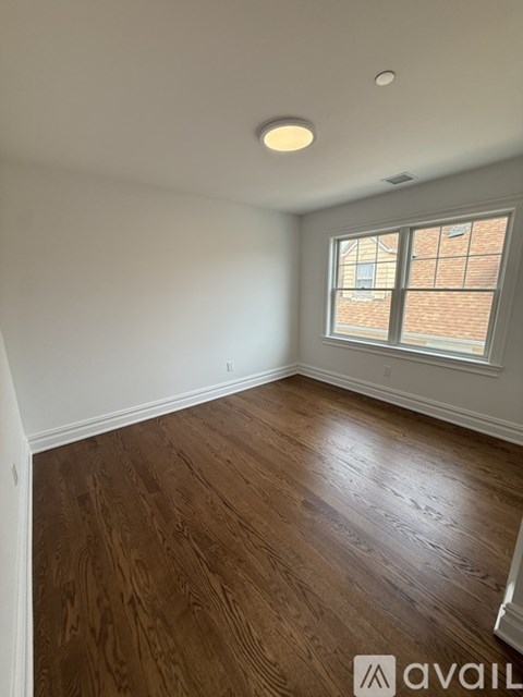 A room with wooden flooring and a window.