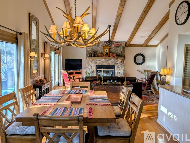 A living room with a red rug and a ceiling fan.