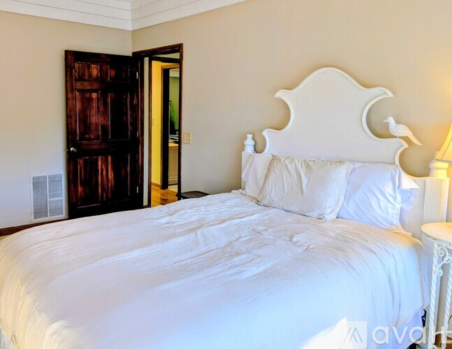 A bedroom with a bed and a stone wall.