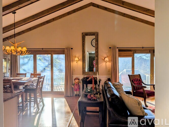 A large wooden dining table is surrounded by chairs in a spacious kitchen.