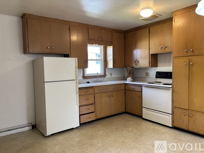 A kitchen with wooden cabinets and white appliances.