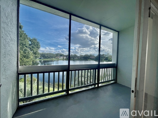 A room with wooden floors and a balcony overlooking a body of water.