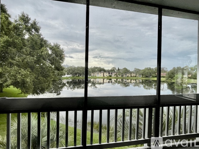 A balcony with a view of a lake and trees.