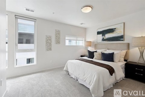 A bedroom with a large bed and a painting on the wall.