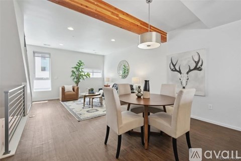 A dining room with a wooden table and chairs.