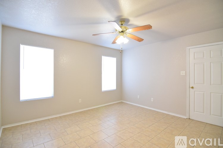 A room with a ceiling fan and a window.