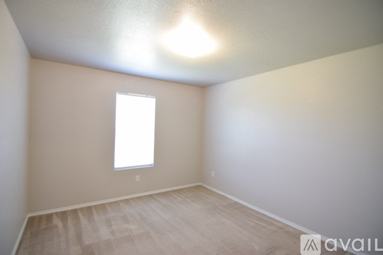 A room with a window and wooden flooring.