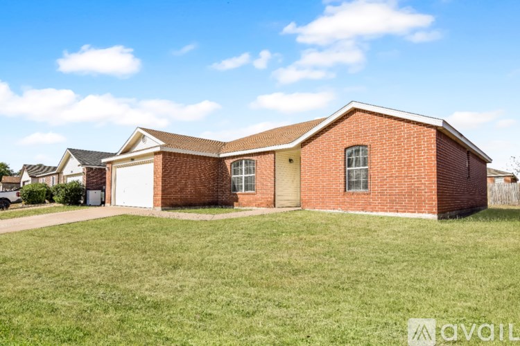 A brick house with a garage door and a window.