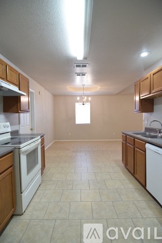 A kitchen with white appliances and wooden cabinets.