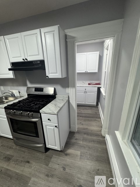 A kitchen with white cabinets and a black stove top oven.