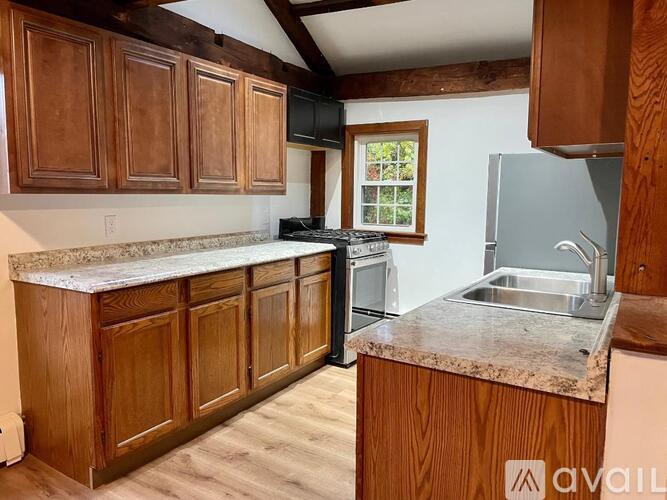 A kitchen with wooden cabinets and a granite countertop.