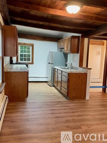 A kitchen with wooden floors and cabinets.