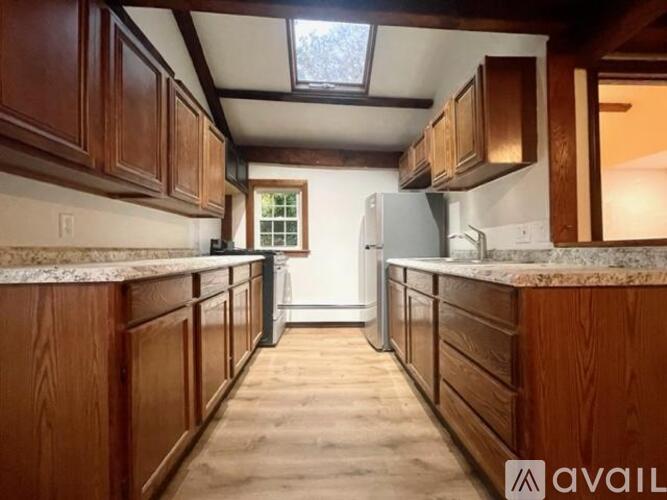 A kitchen with wooden cabinets and a skylight.