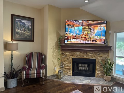 A living room with a fireplace and a painting on the wall.