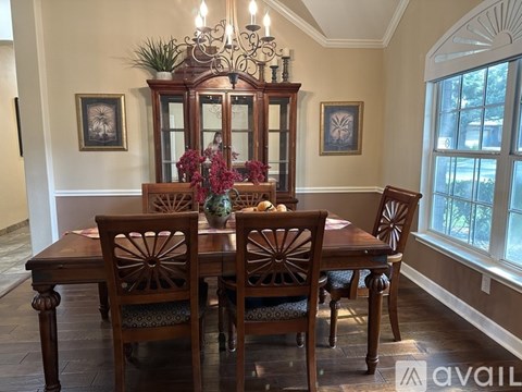 A dining room with a wooden table and chairs.