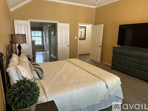 A bedroom with a large bed and a television.