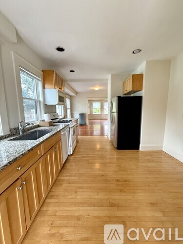 A kitchen with wooden floors and cabinets.