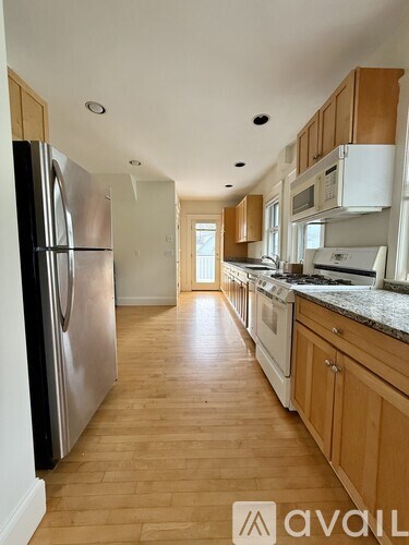 A kitchen with wooden floors and stainless steel appliances.