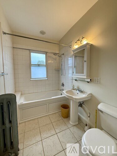A bathroom with a white tub, sink, and toilet.