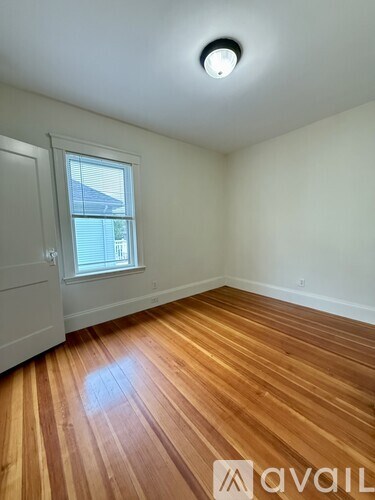 A room with wooden flooring and a window.