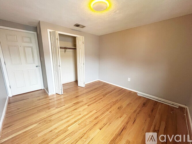 A room with wooden flooring and a white door.