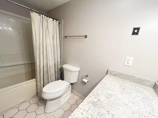 A bathroom with a toilet, sink, and shower.