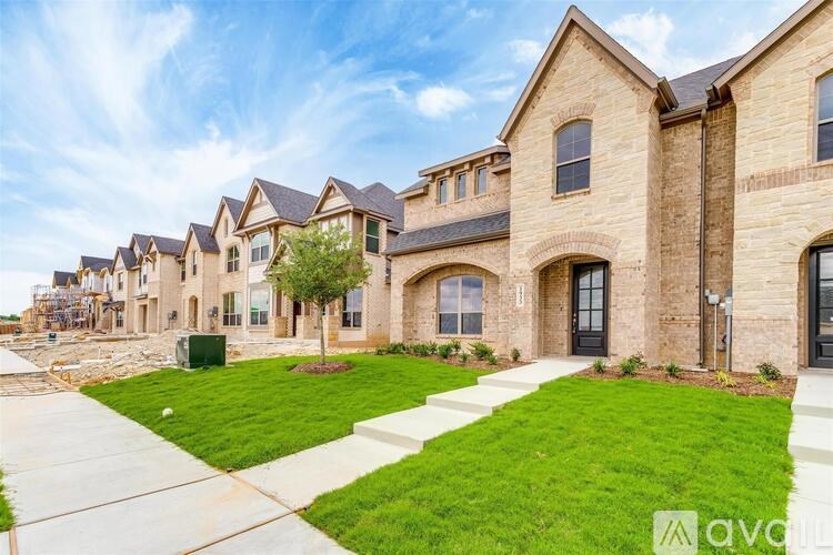 A row of houses with a green lawn in front.