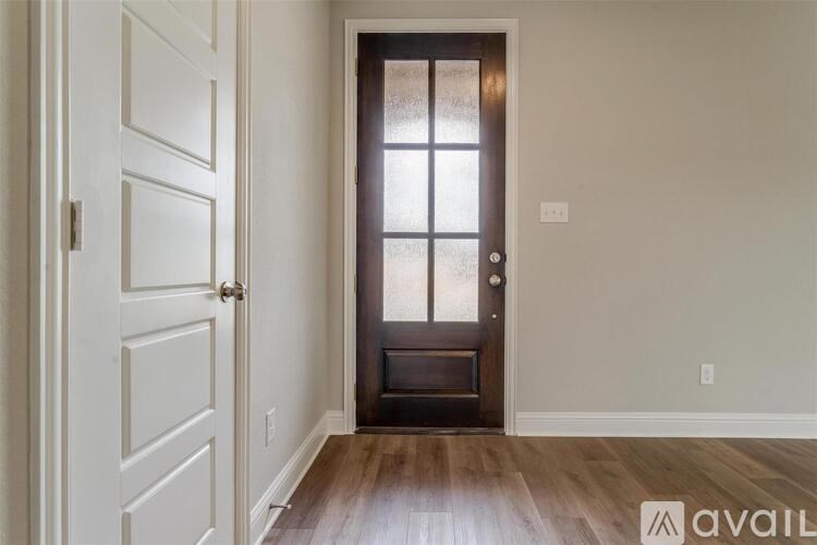 A room with a wooden floor and a door with a glass panel.