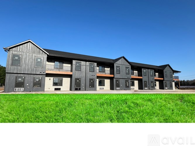 A row of modern buildings with grey exteriors and white doors.