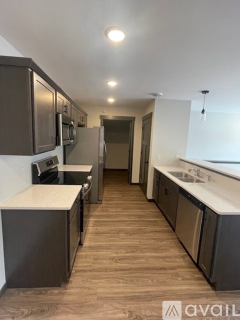 A kitchen with dark brown cabinets and a white countertop.