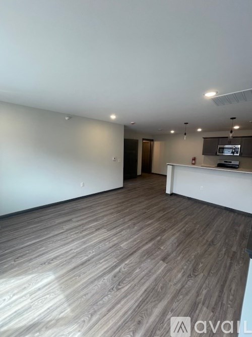 A spacious room with wooden flooring and a white reception desk.