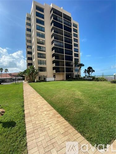 A tall building with a grassy area in front of it.