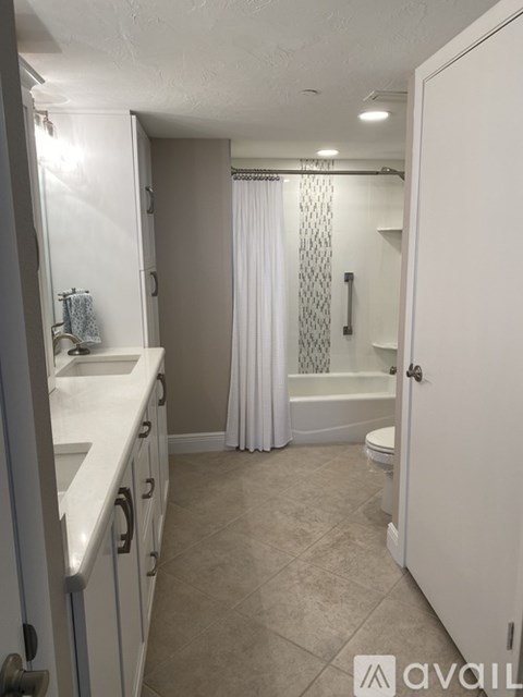 A bathroom with a toilet, sink, and shower.
