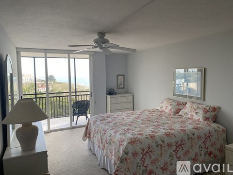 A bedroom with a large bed and a balcony overlooking the city.