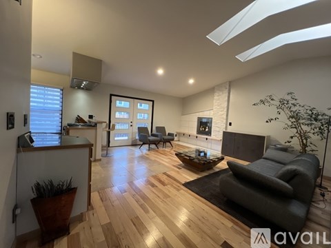 A living room with a grey couch and wooden floors.