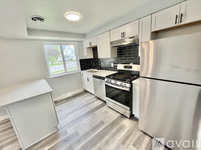 A kitchen with a stove top oven and a refrigerator.