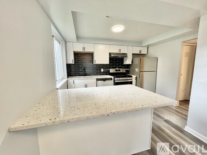 A kitchen with a granite countertop and white cabinets.