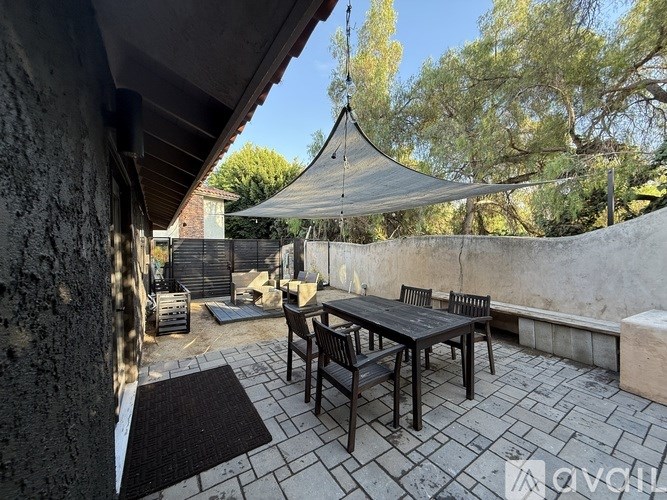 A patio with a table and chairs under a canopy.