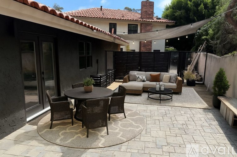 A patio with a table and chairs is set up outside a house.