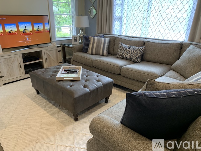 A living room with a grey couch, a coffee table, and a television.