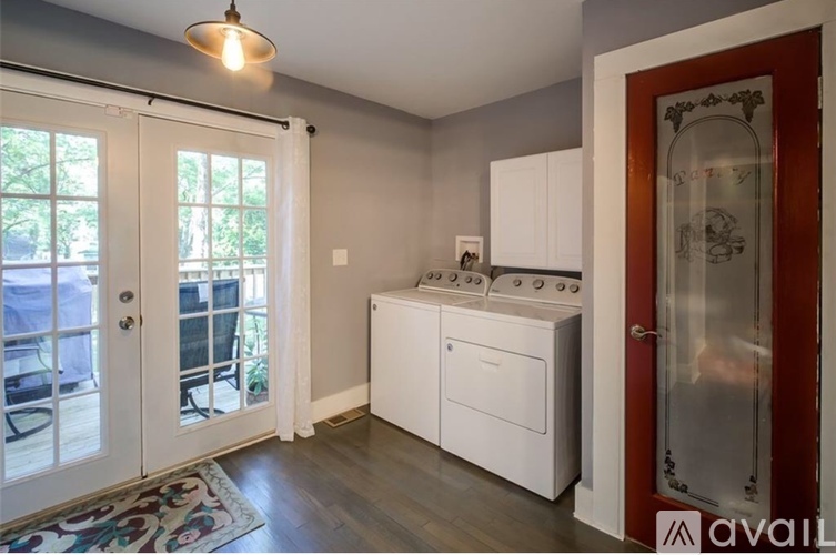A kitchen with white appliances and a wooden floor.