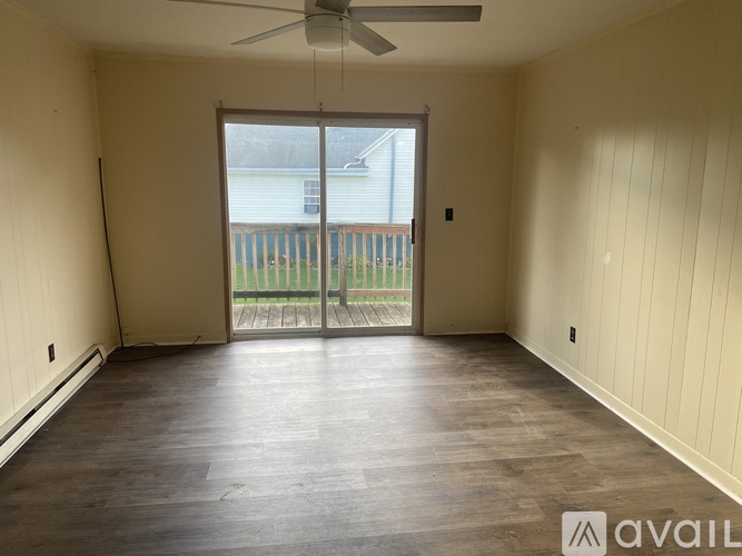 A room with a sliding glass door leading to a balcony.