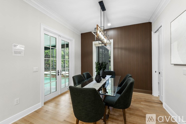 A dining room with a table and chairs.