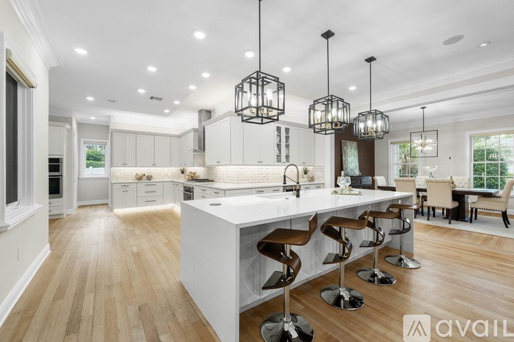 A modern kitchen with a large island and pendant lights.