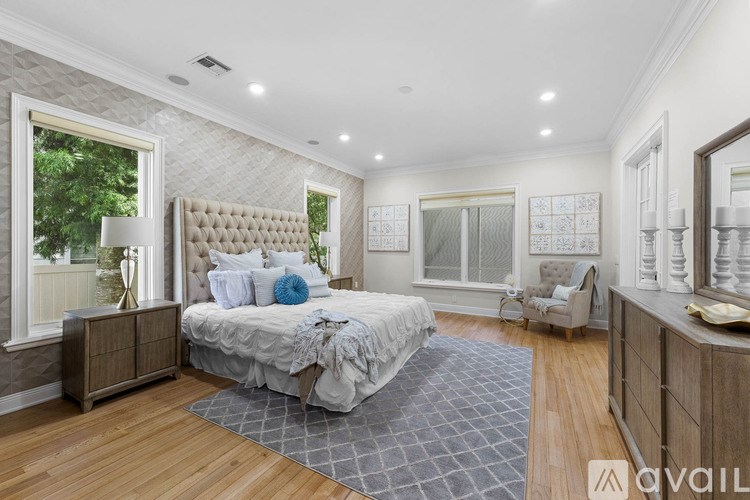 A bedroom with a large bed and a window with a view of trees.