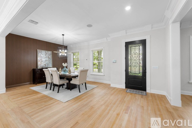 A dining room with a wooden floor and a table set for four.
