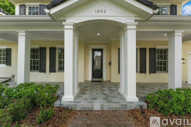 A white house with black shutters and a black door is for sale.