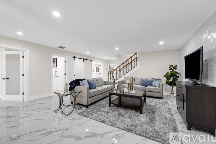 A living room with a staircase in the background.