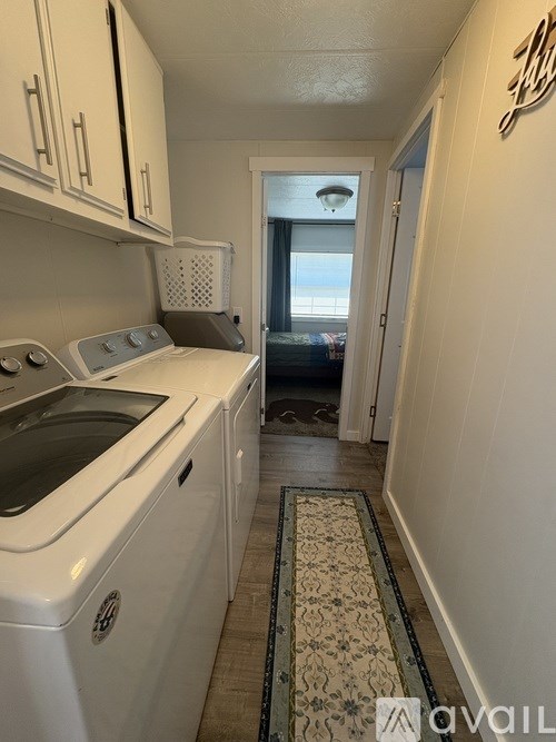 A small white kitchen with a washer and dryer.