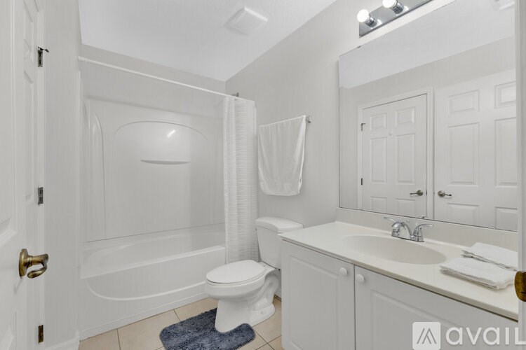 A white bathroom with a toilet, sink, and bathtub.